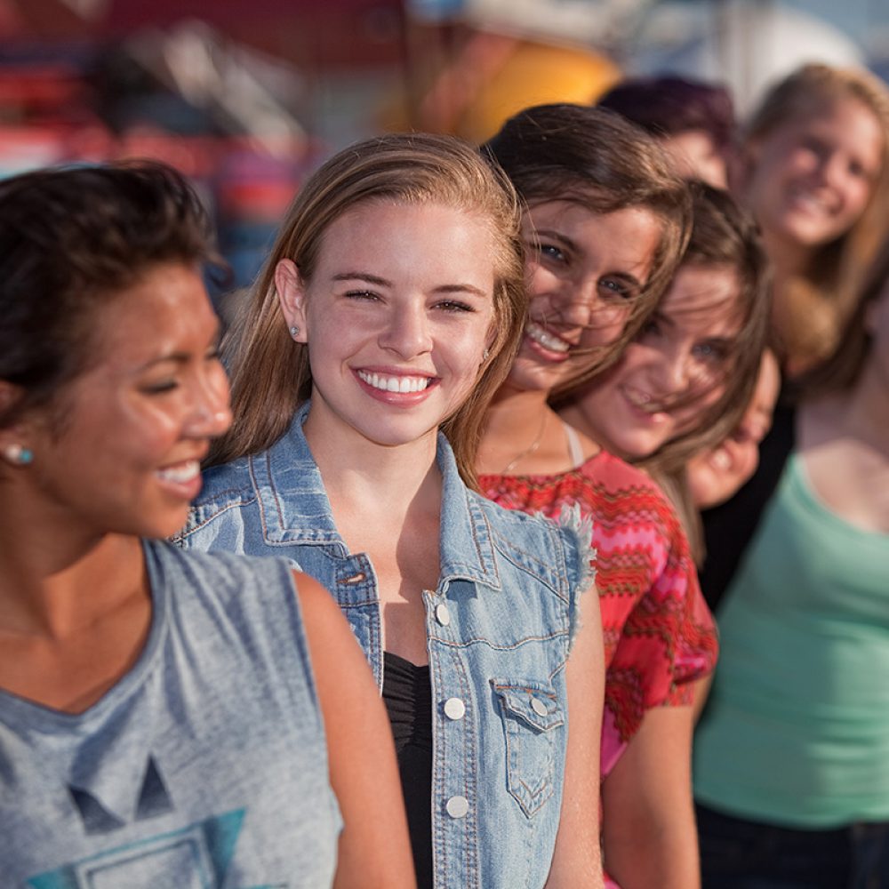 Smiling,Teenage,Girls,Standing,Behind,Each,Other,In,Line